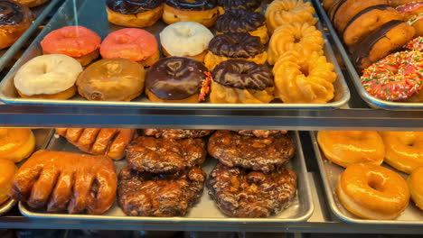 primer plano de una exhibición llena de bocadillos dulces rosquillas pastelería bajo las luces de la tienda
