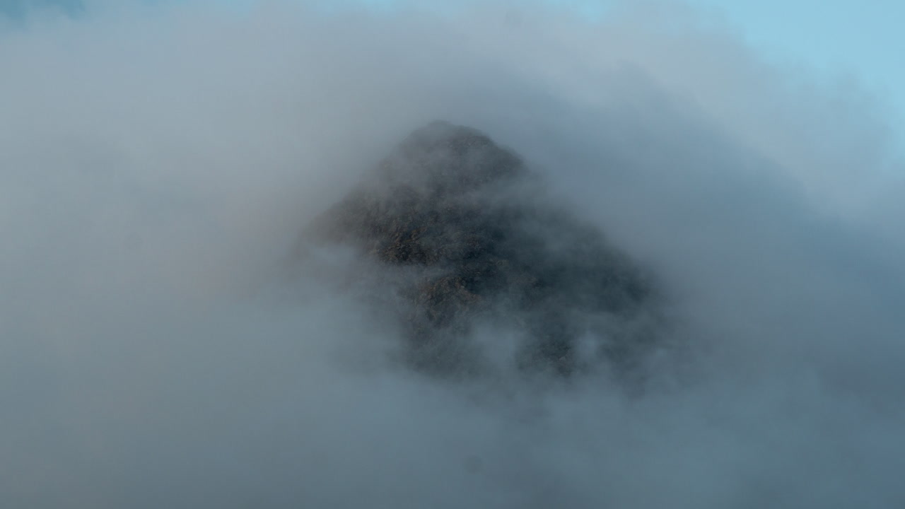 lapso de tiempo de un pico de montaña rocosa golpeado por la luz del sol y las nubes