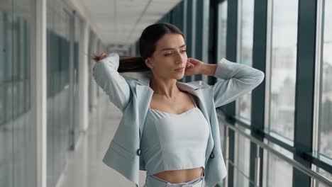 mujer hermosa joven con estilo en un traje posando delante de la cámara