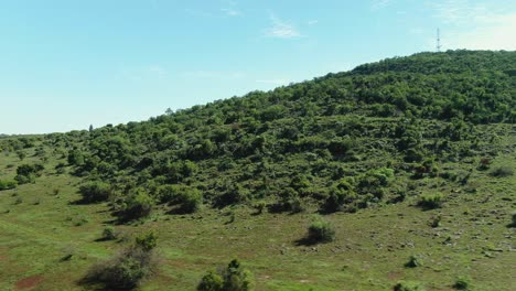 Antena-De-Drone-De-Colina-Con-Un-Mástil-De-Radio-En-La-Cumbre-Follaje-Verde