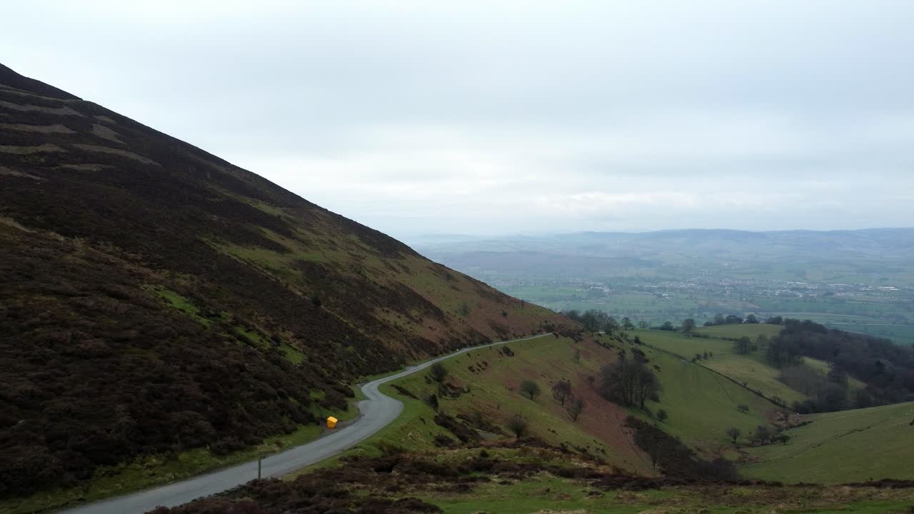 única y estrecha carretera rural que atraviesa el verde paisaje de los valles montañosos de gales dolly a la izquierda