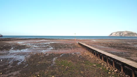 old wooden boardwalk on a dry pebble beach overlooking the ocean, wales