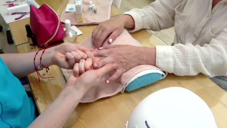 una mujer haciendo una manicura en un salón de uñas.