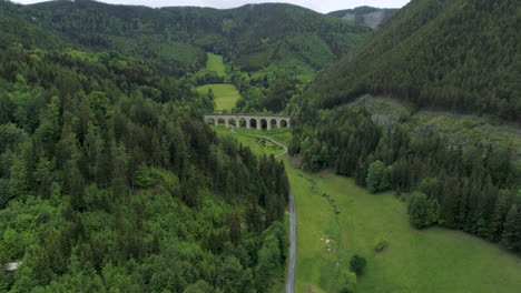 aerial drone shot of a street and a viaduct between mountains, 4k uhd, semmering, austria