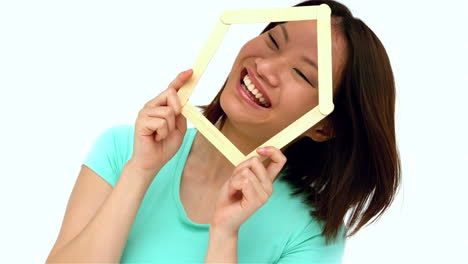 mujer asiática feliz sosteniendo la forma de la casa