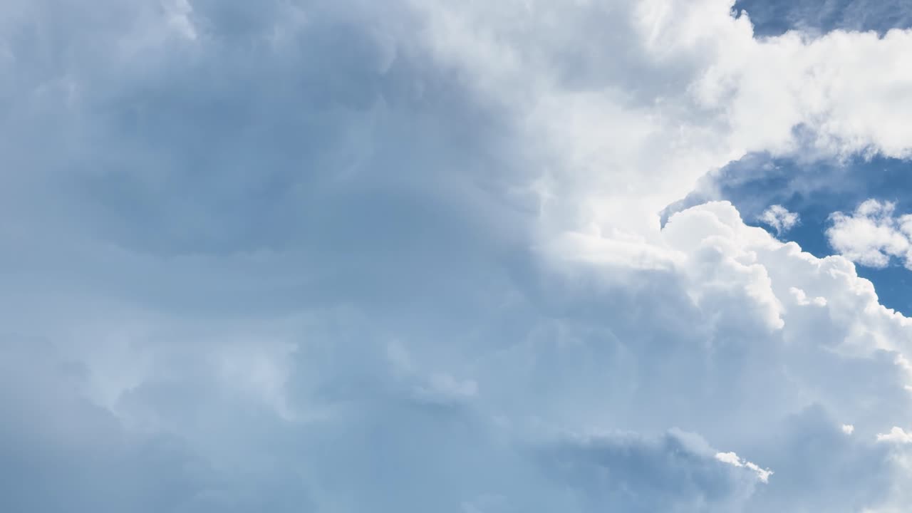 Dynamic cumulus and cumulonimbus clouds build and shift rapidly in bright daylight, timelapse sequence