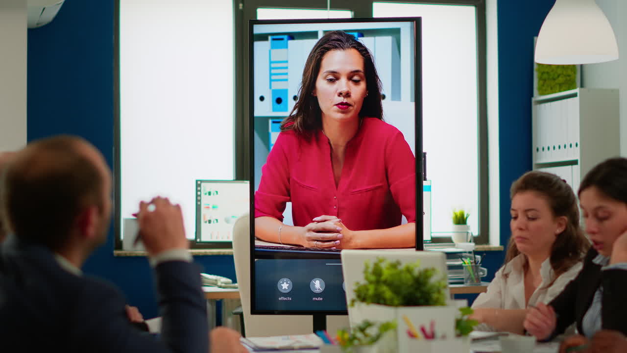 un equipo diverso de compañeros de trabajo hablando con el gerente del proyecto usando una cámara web