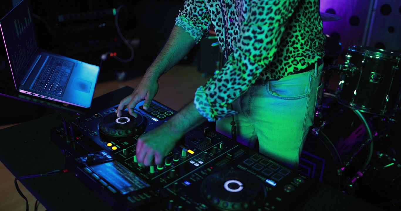 Professional DJ Mixing Music on Controller with Neon Lights