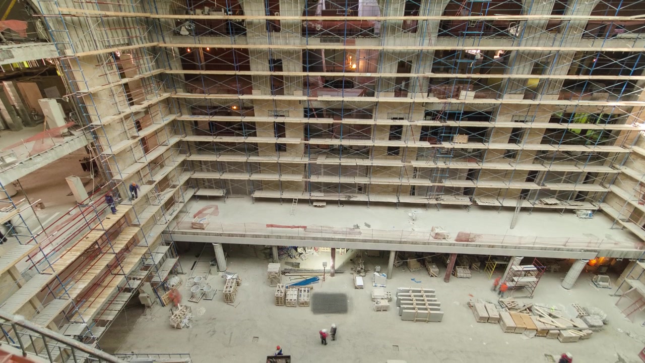 Vista aérea de equipos y materiales de construcción con andamios y herramientas en el interior de un piso de un edificio de gran altura timelapse, rascacielos. Edificio en construcción. Obras interiores en curso.