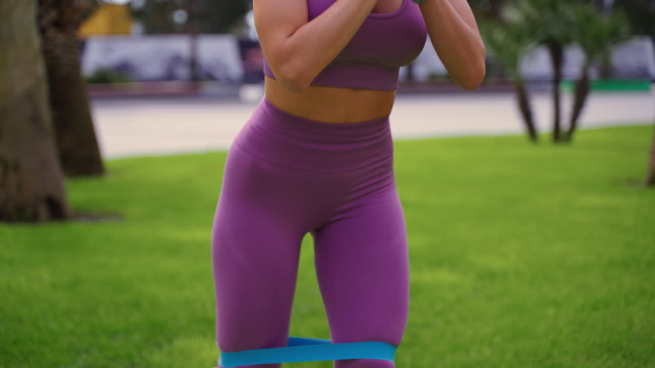 mulher fazendo exercícios de banda de resistência no parque