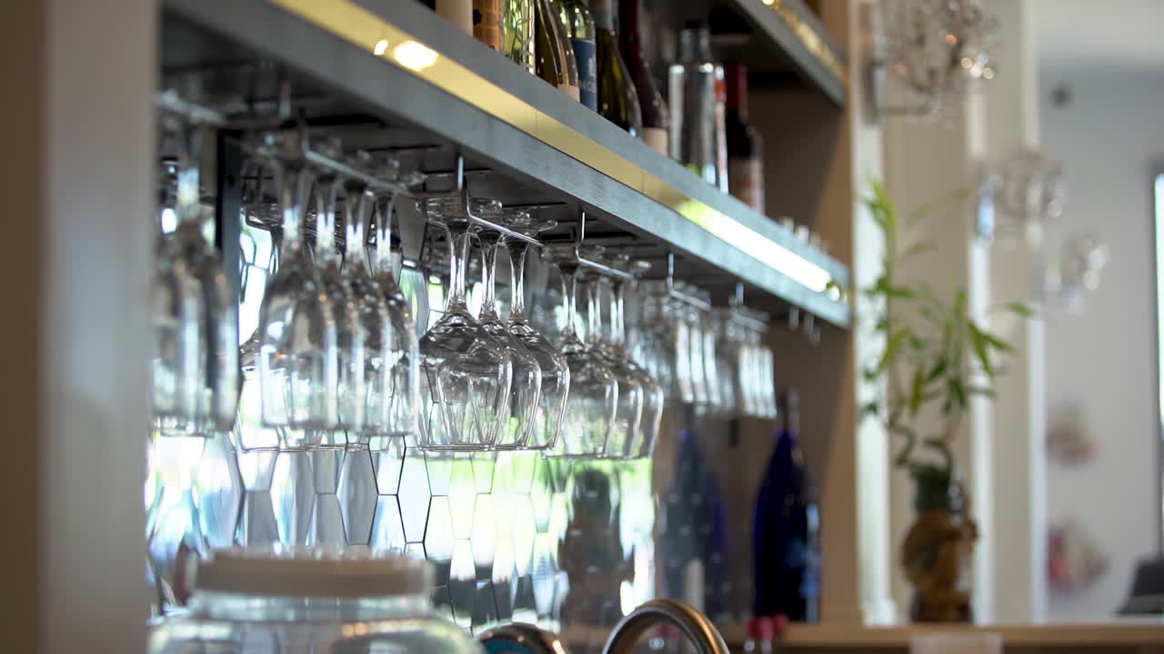 close up wine glasses hanging up at a bar
