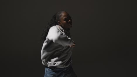 full length studio portrait shot of young woman dancing in spotlight 3