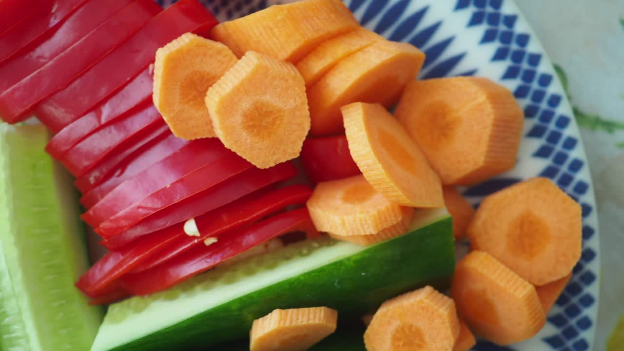 Close-up of Freshly Sliced Carrots, Red Bell Pepper, and Cucumber
