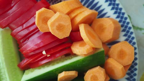 close-up of freshly sliced carrots, red bell pepper, and cucumber