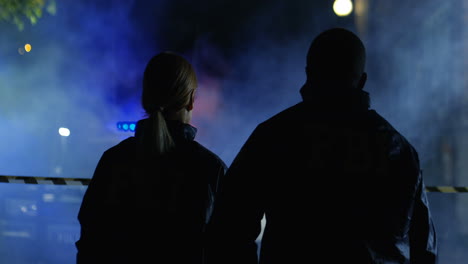 Rear-Of-The-Mixed-Races-Man-And-Woman-From-Fbi-Going-At-Night-Street-To-Crime-Scene