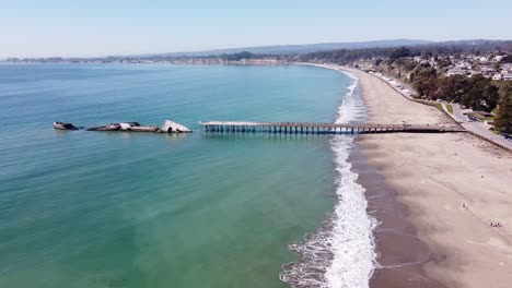 foamy ocean waves hitting sandy california coast with pier and sunken ss palo alto freighter ship