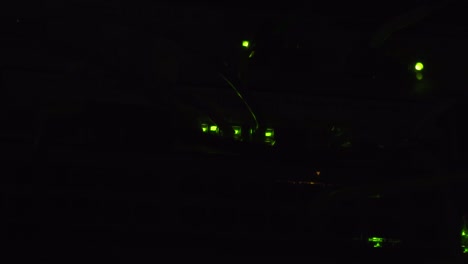 luces indicadoras led verdes parpadeando en una habitación oscura, información de procesamiento de enrutadores