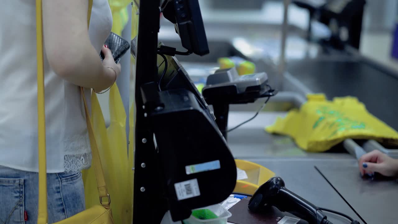 chica joven de primer plano paga por las compras en la caja.