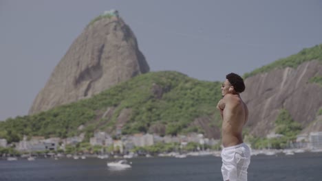 a man exercises by the water with sugarloaf mountain in rio de janeiro