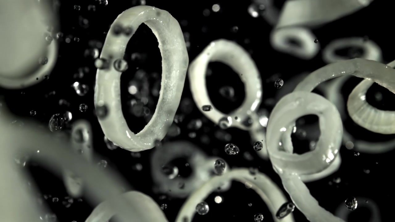 Fresh Onion Rings with Water Droplets Falling in Slow Motion