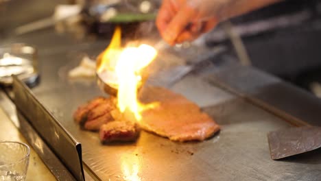 chef cooking steak with dramatic flame show