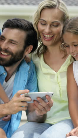 familia feliz buscando un teléfono inteligente