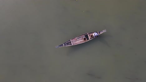 pequeño barco de madera tradicional con pescador, aéreo de arriba hacia abajo