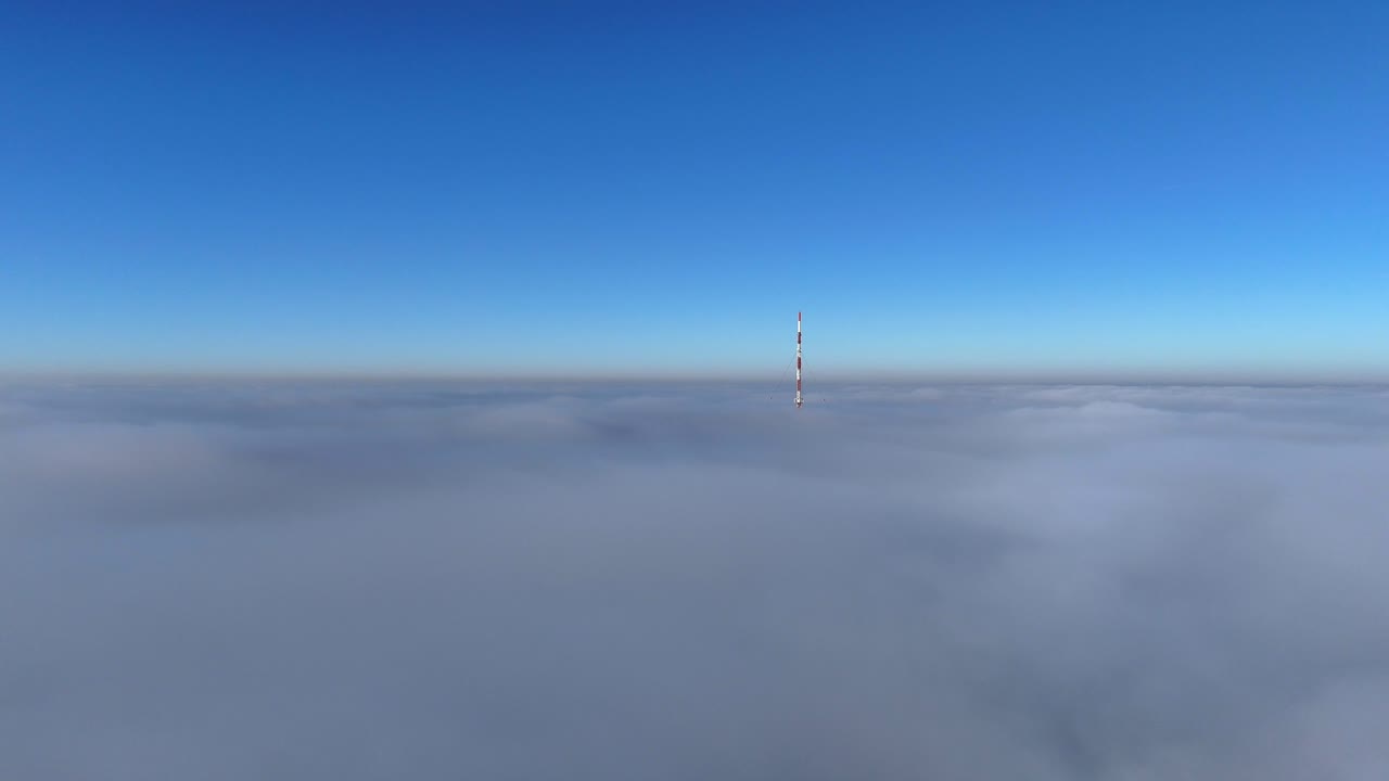 Red White Telecommunication Towers rising over dense cloudscape and blue sky in USA. Drone flight over grey clouds. Wide shot. 5G Signal Wifi Antenna Theme in America.