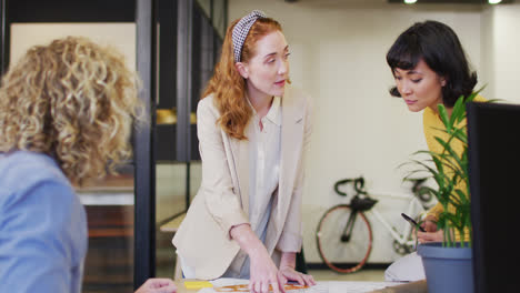 Happy-diverse-business-people-discussing-work-with-documents-at-office