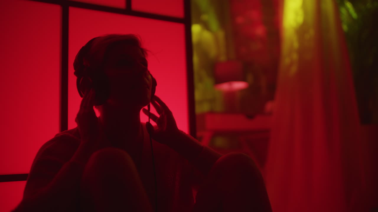Donna che ascolta musica in una stanza illuminata di rosso