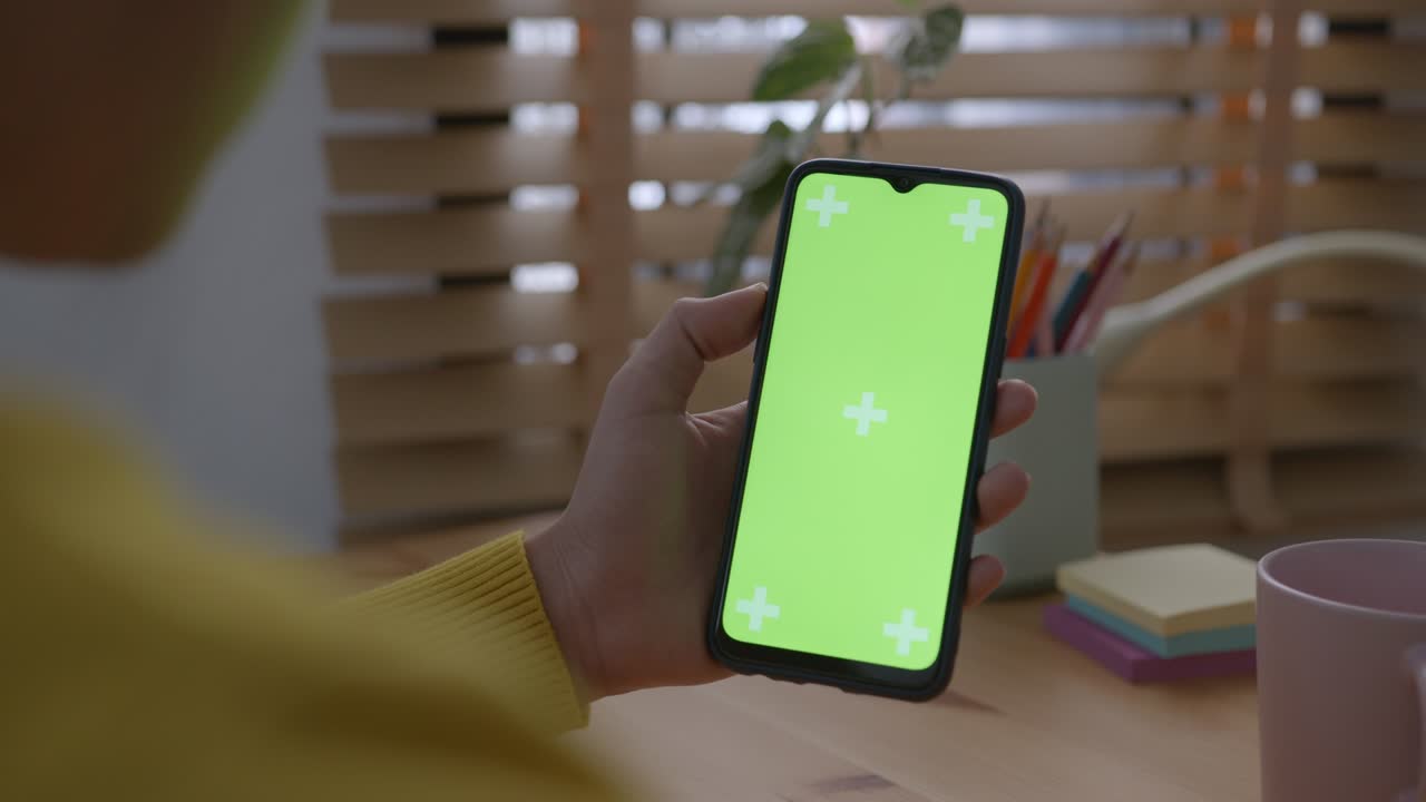 teléfono inteligente digital en blanco en la mano de las mujeres de asia, teléfono móvil pantalla verde