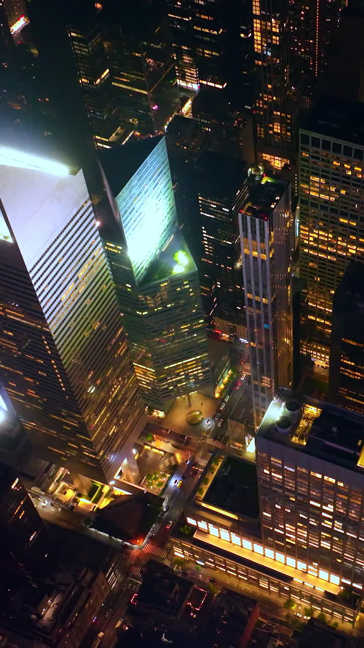 Majestic scenery of skyscrapers and multi-storied buildings of New York. Drone footage rising above the wonderful city at night time. Vertical video