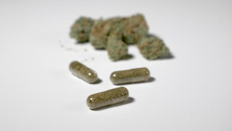 panning past three capsules of medical cannabis and dried marijuana in background. room for copy on left.