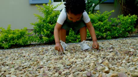 Low-angle-view-of-cute-little-black-baby-playing-in-back-yard-of-their-home-4k