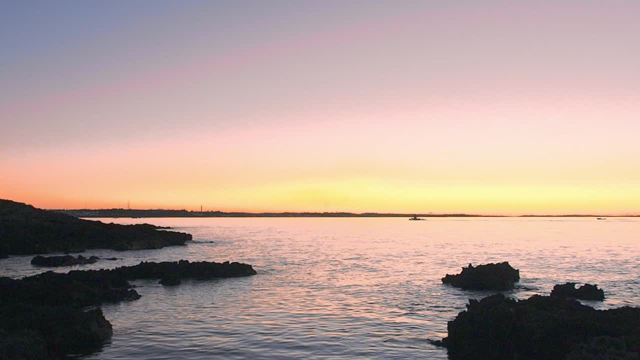 A beautiful sunset, and boats are coming back to shore.