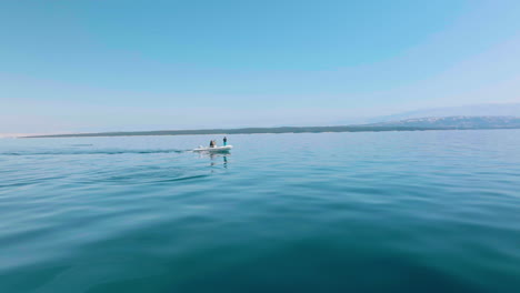 a small project research boat sailing across the blue waters of adriatic sea to search for dolphins in lošinj island, croatia - wide shot