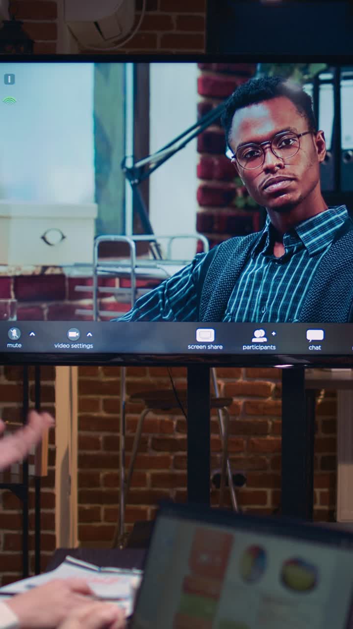 Vertical video: Employees talking with team leader in remote business meeting