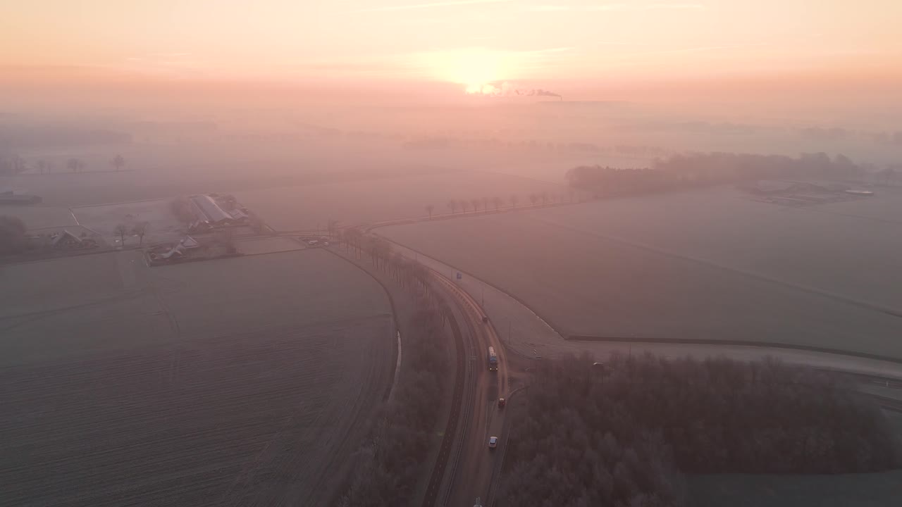네덜란드 농경지 위의 안개가 가득한 해가 뜨고