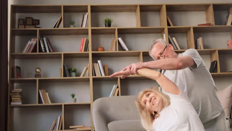 grayhaired grandfather and grandmother work on their health by doing simple fitness exercises grayhaired grandfather and grandmother work on their health by doing simple fitness exercises the woman stretched in a cool way stretching her arms out to her side they both enjoy practicing fitness