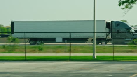 epic slow motion of a reefer semi tractor and trailer driving on interstate