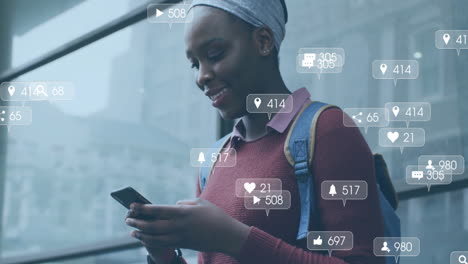 Animation-Von-Mediensymbolen-über-Einer-Afroamerikanischen-Frau,-Die-Ihr-Smartphone-Nutzt