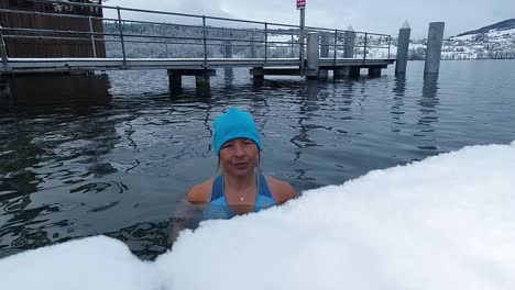 Woman-taking-an-ice-bath-in-a-lake-in-Switzerland-during-winter-with-snow