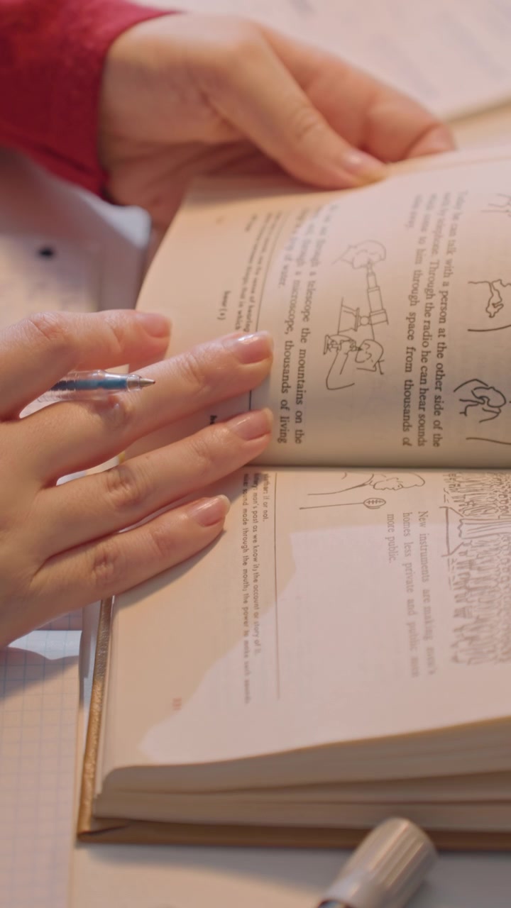 Close up of young woman. Her hands interact with printed material revealing diagrams like bridges charts labeled DEATH on y axis 1905 1926 x axis. Pen is held between her fingers