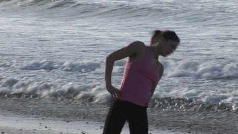 mujer estirándose en la playa