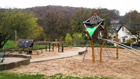 fly through drone shot of a beautiful playground at the foot of venusberg, bonn, germany on a cool autumn morning