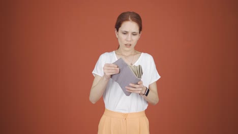 penniless woman looking at her empty wallet.