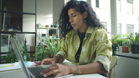 hispanic businesswoman using laptop in office