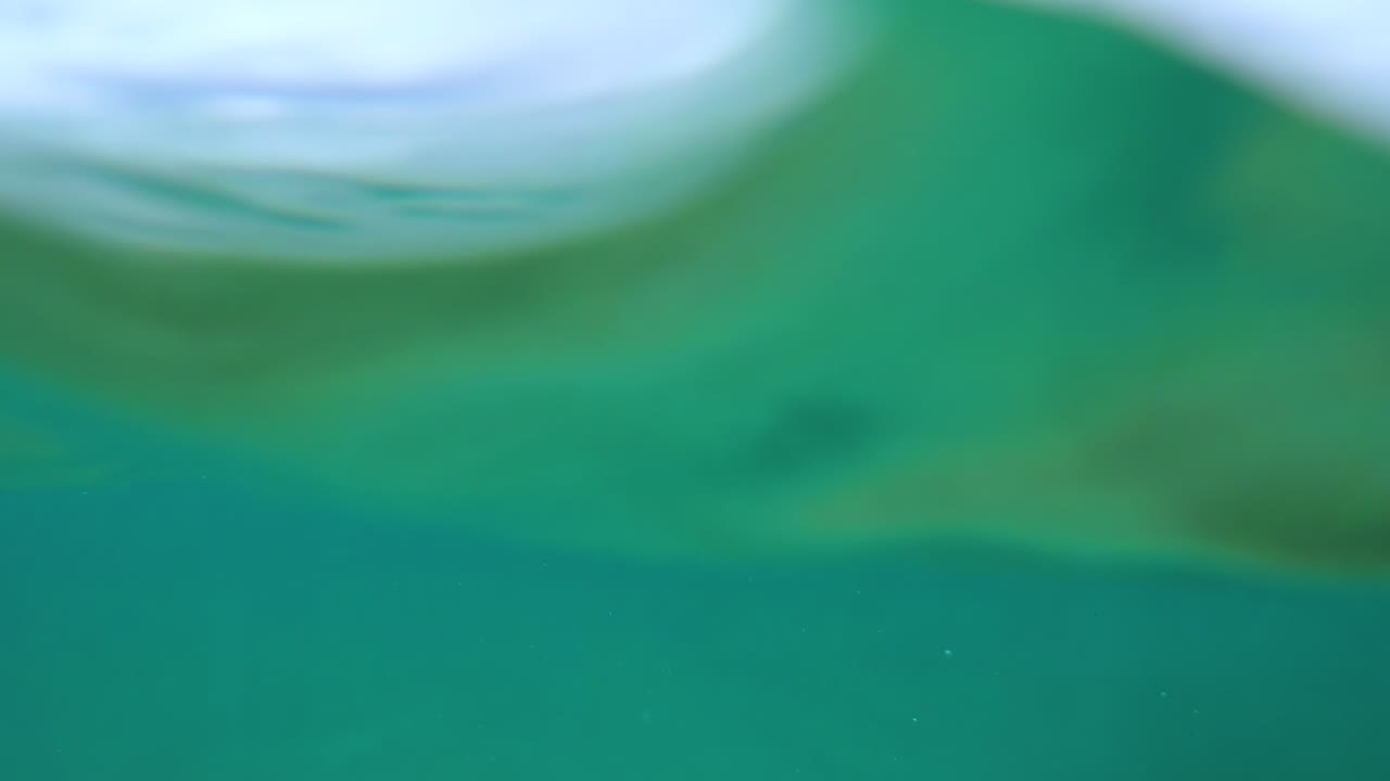 POV: Onde dell'oceano che si infrangono sulla telecamera in acque aperte a livello dell'acqua.