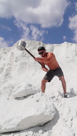 man doing hammer strike during exercise outside. sport fitness man hitting stone with hammer during crossfit training vertical video