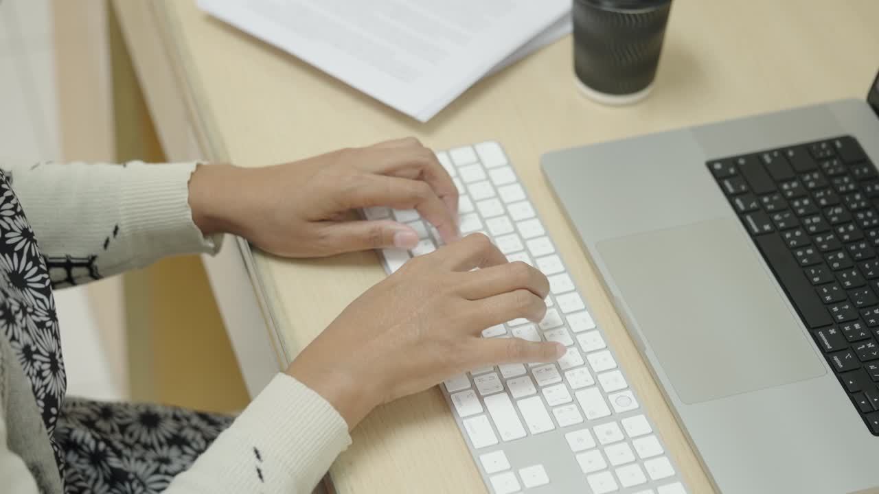 las manos de la mujer de negocios escribiendo en el teclado de la computadora portátil para buscar información, informe de investigación de marketing en el escritorio de la oficina